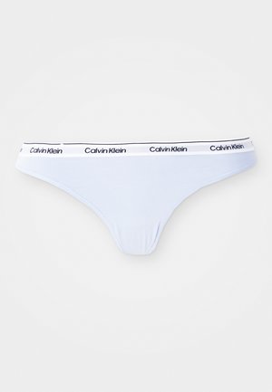 Light blue thong underwear with a white elastic waistband featuring repeated black "Calvin Klein" logos.