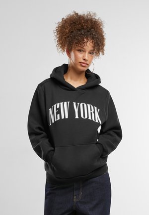 Melnā kapuce ar lielu baltu "NEW YORK" uzrakstu priekšpusē. Iekļauj attaukošanas kapuci un priekšējo kabatu, izgatavota no mīksta materiāla.