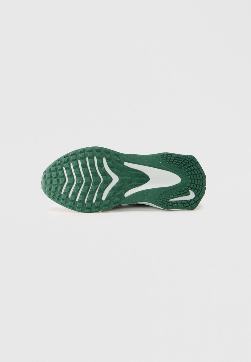 Suela de zapatilla de running en goma verde con un patrón texturizado. Presenta un diseño de olas blancas y secciones de agarre en contraste para mayor tracción.