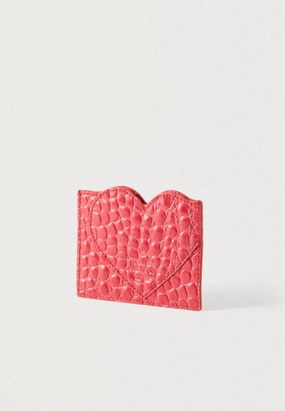 Ροζ θήκη καρτών με υφασμάτινο, καπιτονέ σχέδιο και πλατύτερη κυματιστή άνω άκρη. Κατασκευασμένη από συνθετικό υλικό με ανάγλυφη λεπτομέρεια λογότυπου.