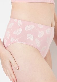Helle rosa Baumwollunterwäsche mit einem weißen Blattmuster, ausgestattet mit einem elastischen Bund und einem nahtlosen Schnitt entlang der Beine für zusätzlichen Komfort.