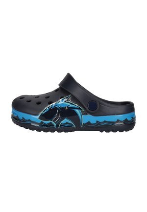 Sabot noir sans lacets avec des trous de ventilation et un motif de requin bleu sur le côté, contrastant avec des motifs de vagues bleues sur la semelle.