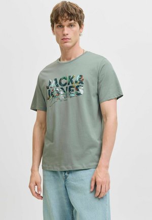 Svijetlozelena pamučna majica s hrabrim grafičkim printom u tamnozelenoj i bijeloj boji, na kojem piše "JACK & JONES", s ležernim kratkim rukavima.