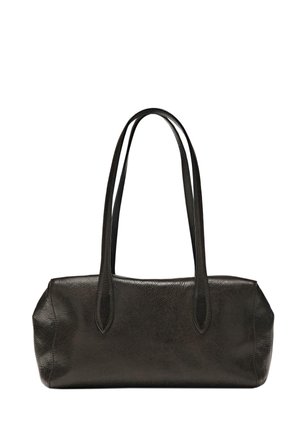 Femme aux cheveux attachés en chignon, portant une tunique noire sans manches, un pantalon noir, des ballerines noires, portant un sac à main en cuir marron sur l'épaule, vue de dos.