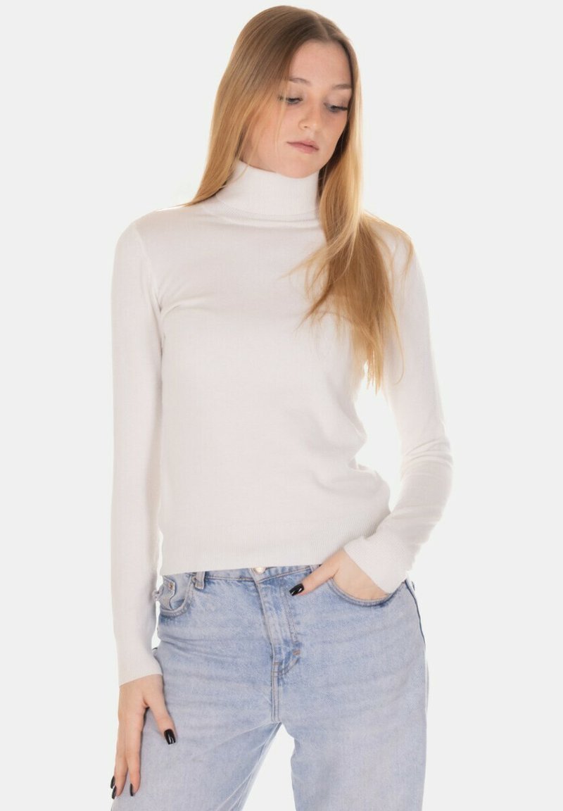 Maglione bianco a collo alto con texture a coste, design aderente, maniche lunghe, abbinato a jeans a vita alta azzurri chiari.