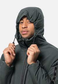 Dunkelgrüne Kapuzenjacke mit Rei�ßverschlussfront, verstellbarem Kordelzug an der Kapuze und Reißverschlusstaschen an den Seiten. Glattes, wetterbeständiges Material.
