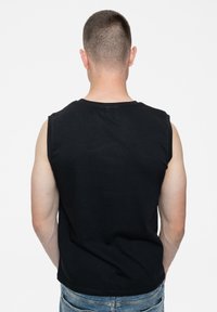 Black sleeveless cotton shirt with a round neckline. The fabric appears soft, with a casual fit, featuring no visible patterns or graphics.