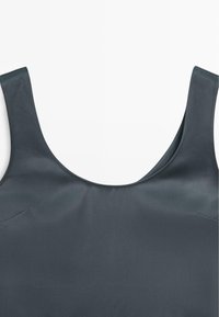 Grijze tanktop met een gladde, glanzende textuur. Voorzien van brede banden en een ronde halslijn. Geen zichtbare patronen of accenten.