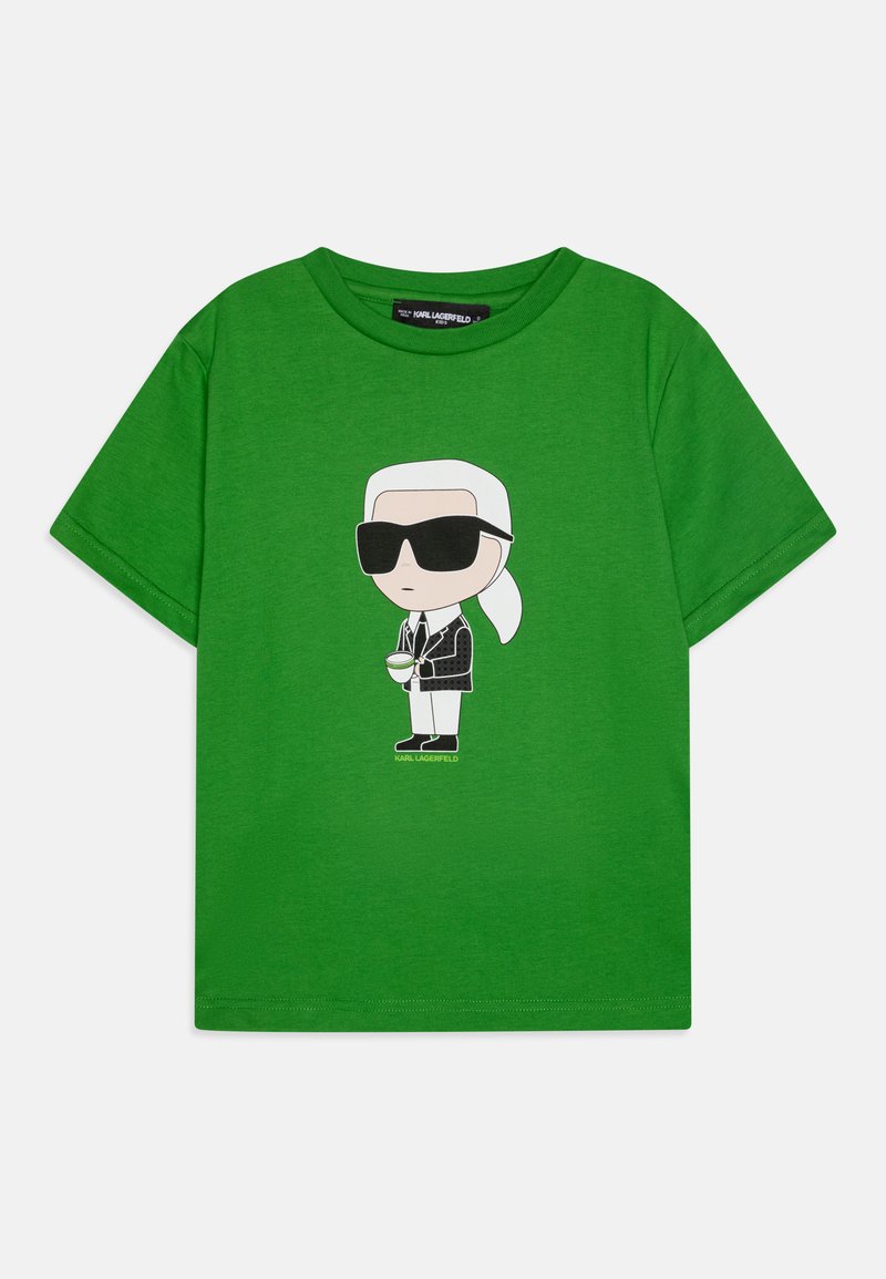 T-shirt de algodão verde com uma figura de cartoon com cabelo branco, óculos de sol e um fato preto. Mangas curtas e decote redondo.