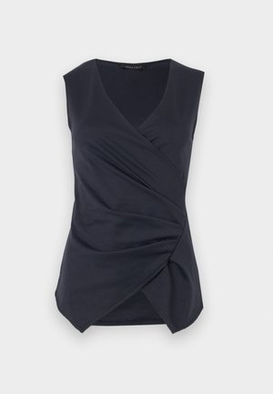 Sleeveless dark navy wrap-style top with V-neck and gathered draped detail at front hem, labeled Anna Field.