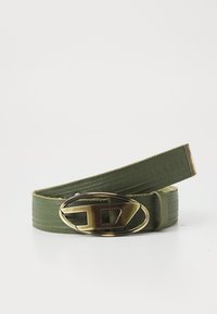 Ceinture en cuir vert avec une texture lisse et une boucle ovale en ton doré avec un design découpé stylisé. Les extrémités sont plates et cousues.