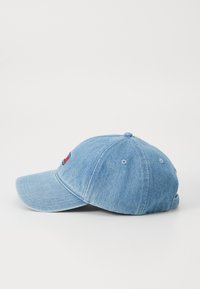 Lyseblå denimkasket med buet skygge, broderet logo foran, luftningshuller, og justerbar rem bagpå.