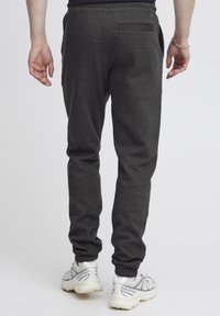Grijze sweatpants gemaakt van een zachte stof, met een taps toelopend ontwerp, elastische boorden, zijzakken en een achterzak.