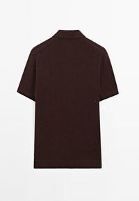 Kortärmad polo i mörkbrunt tyg. Har klassisk krage och en minimalistisk design utan synliga mönster eller dekorationer.