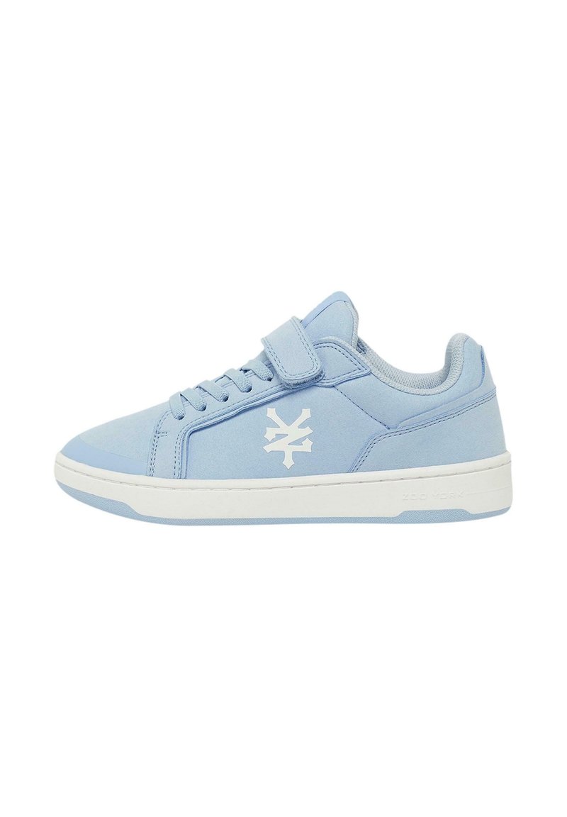 Helle blaue Sneaker aus weichem Material mit weißem Logo-Detail, Schnürung vorne und verstellbarem Riemen. Weiße Gummisohle. Niedriges Design.