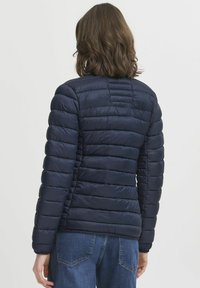 Námornícka puffer bunda s prešívaným dizajnom, úzkymi horizontálnymi pruhem a priliehavým strihom, s okrúhlym golierom a elastickými manžetami.