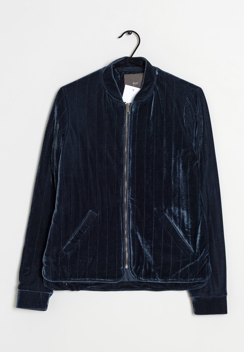 Veste zippée en velours bleu marine avec des rayures verticales subtiles, deux poches avant et un col rond, suspendue sur un cintre noir.