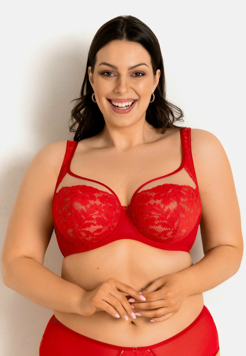 Czerwony koronkowy biustonosz z przezroczystymi panelami, kwiatowymi wzorami, fiszbinami podtrzymującymi i regulowanymi ramiączkami. Gładka tkanina na bazie z ozdobą z przodu.