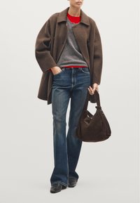 Brown wool coat, gray sweater, red shirt, denim jeans, and a brown suede handbag. Flared jeans and black ankle boots complete the look.