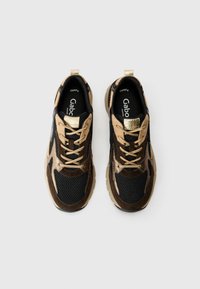 Sneakers featuring a mesh and suede upper in black and brown, accented with gold detailing, round toe, and beige laces.