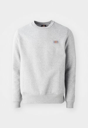 Sweatshirt cinza com gola redonda, punhos e bainha canelados, feito de um material de algodão macio. Apresenta um pequeno logótipo no lado esquerdo do peito.