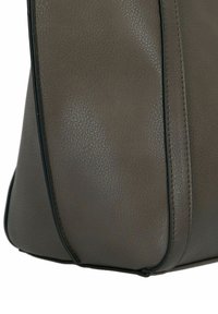Borsa in finta pelle marrone con texture e cuciture visibili, dalla forma arrotondata. Presenta un profilo nero a contrasto lungo i bordi.