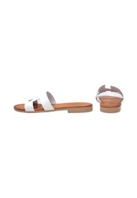 White leather slide sandals with two wide straps, a brown leather insole, and a flat tan outsole, featuring an open back design.