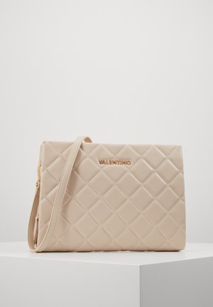 Sac à main matelassé beige avec une texture lisse, quincaillerie dorée et une bandoulière amovible. Présente le logo "VALENTINO" embossé sur le devant.