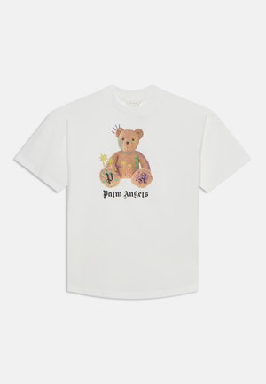 T-shirt blanc avec un motif d'ourson coloré et décoré et le texte "Palm Angels" sous l'ourson sur le devant.