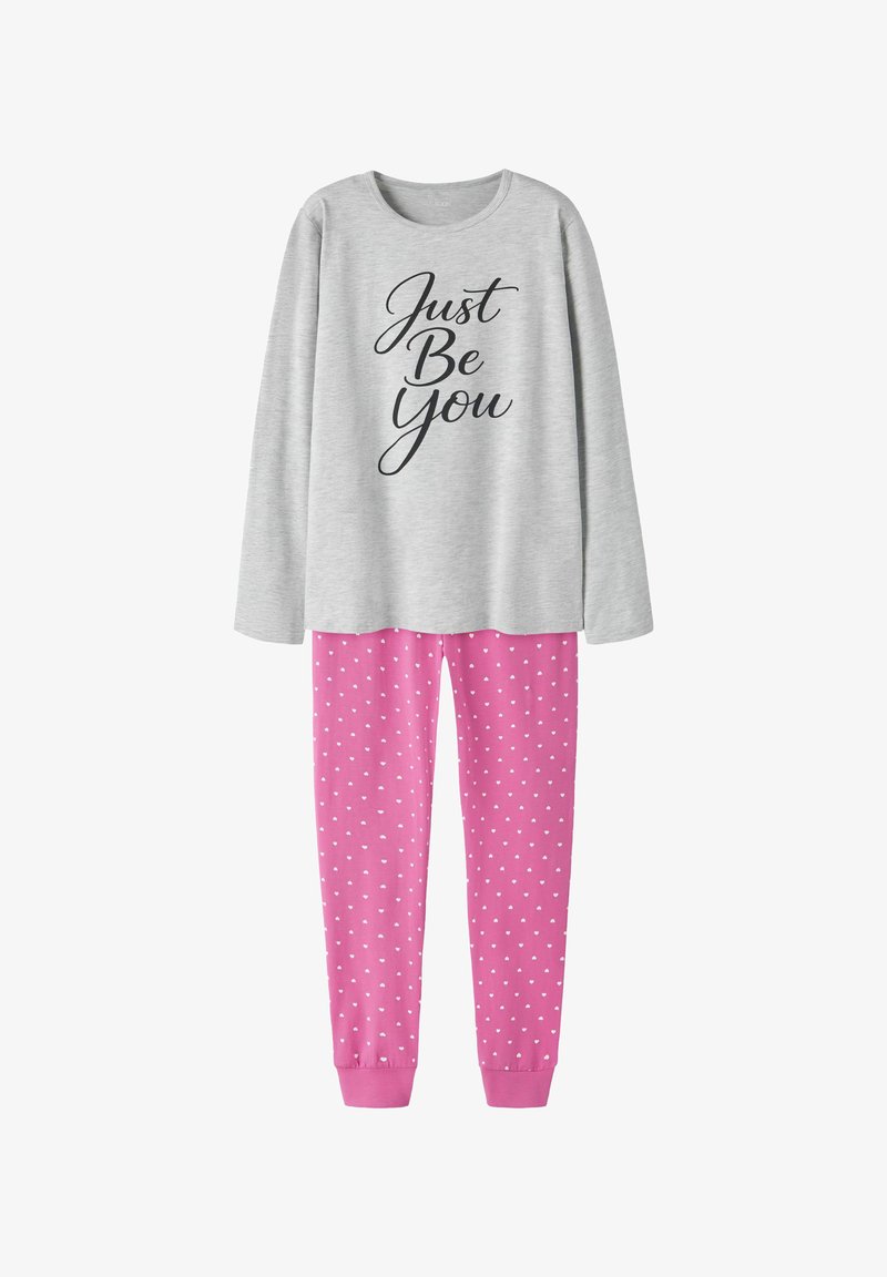 Haut à manches longues gris clair avec le texte "Just Be You" assorti à un pantalon rose avec de petits motifs de cœurs blancs.
