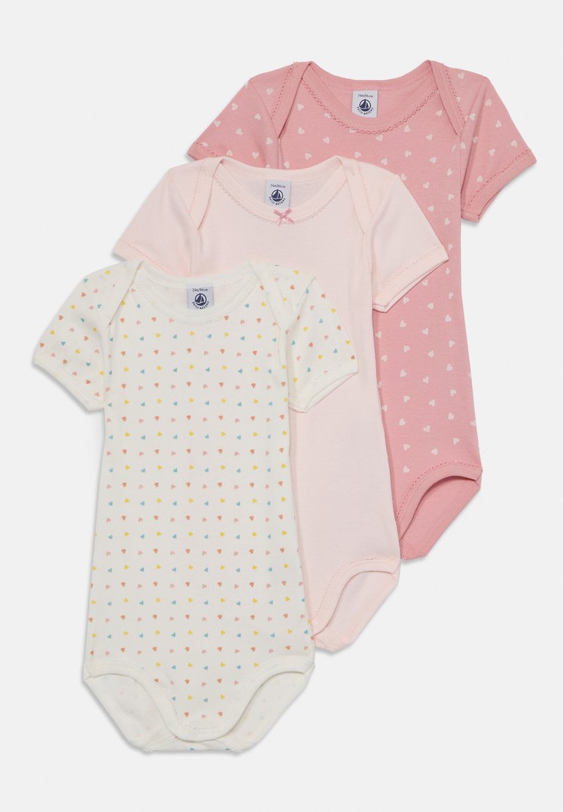 Trois bodies à manches courtes dans des nuances de rose : un uni rose avec des cœurs, un rose clair, et un crème avec un motif de cœurs multicolores. Matière en coton.