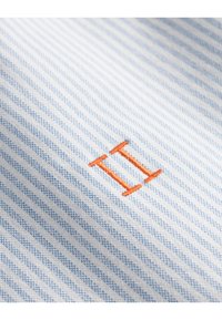 Blauw en wit gestreepte stof met een gladde textuur, voorzien van een oranje geborduurd "II" logo. De strepen zijn smal en gelijkmatig verdeeld.
