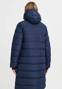 Marineblauer Puffer-Mantel mit horizontaler Steppung, Kapuze und langen Ärmeln. Der Stoff wirkt glatt und glänzend mit einer leicht gepolsterten Textur.