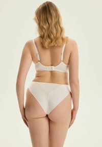 Biały stanik i pasujące majtki z wysokim stanem mają gładki, miękki materiał, regulowane ramiączka, zapięcie na haftkę oraz bezszwowy krój.