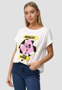 Witte katoenen T-shirt met een kleurrijke Mickey Mouse graphic en tekstontwerp. Korte mouwen en een ontspannen pasvorm, gecombineerd met donkerblauwe jeans.