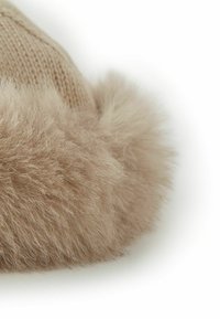 Stickad mössa med en mjuk, beige fuskpälskant. Designen har en rundad form med en texturerad stickad kropp som ökar värme och komfort.