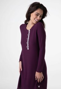 Abito viola a coste con maniche lunghe, scollo rotondo, abbottonatura in pizzo bianco e piccolo cuore in rilievo vicino all'orlo.