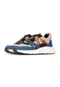 Zapatillas multicolores con denim azul, acentos negros, detalles en rosa y dorado, parte superior texturizada y una suela blanca gruesa.