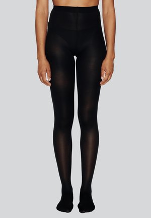 Leggings noires opaques avec une taille haute, texture lisse et design ajusté. Présentent une construction sans couture et un ajustement à la cheville.