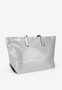 Bolso tote plateado con un acabado texturizado, que presenta dos asas de cuero negro y una forma rectangular estructurada.