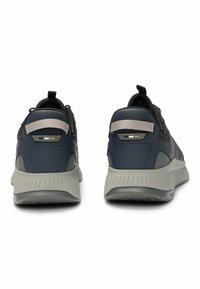 Scarpe da ginnastica blu con tomaia in mesh e suola in gomma grigia. Presentano un colletto imbottito, dettagli riflettenti e una linguetta sul tallone.