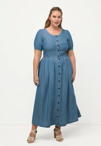Denim midi šaty s nafouknutými rukávy, kulat�ým výstřihem a předním zapínáním na knoflíky. Světle modrá barva, texturovaná tkanina s hladkým povrchem.