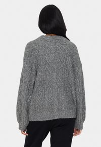 Grauer Strickpullover mit strukturiertem Zopfmuster, Rundhalsausschnitt, überschnittenen Schultern und geripptem Saum. Weiches, dickes Material.