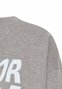 Grijze katoenen t-shirt met een zachte textuur, voorzien van vet wit tekst op de achterkant en een ronde halslijn.