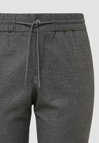 Graue Jogginghose aus weichem Material, mit einem elastischen Gummizug und einer Kordel zum Verstellen, sowie einem minimalistischen Design ohne Muster oder Akzente.