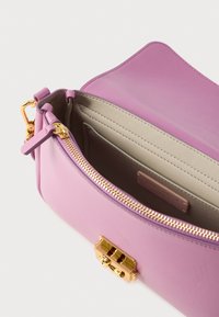 Μωβ δερμάτινη τσάντα με χρυστό φερμουάρ και κούμπωμα. Το εσωτερικό διαθέτει ομαλή ανοιχτό μπεζ επένδυση και θήκη για κάρτες.