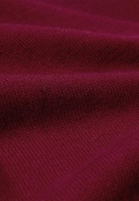 Tissu bourgogne avec un motif de tricot texturé ; présente une surface douce, légèrement duveteuse et un tissage homogène.