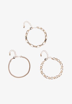 Tre guldarmbånd: et med forlængede led, et fleksibelt spiraldesign og et med runde led. Hvert af dem har en kædeforlængelse.