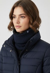 Navy puffer jacket with a high collar, featuring a ribbed knit navy cowl neck. Includes snap fasteners and zip closure. Soft texture.