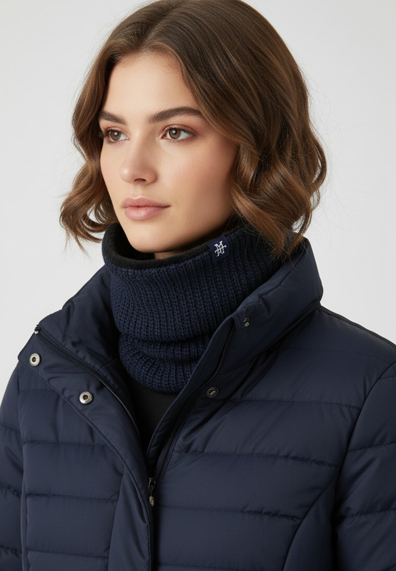 Navy puffer jacket with a high collar, featuring a ribbed knit navy cowl neck. Includes snap fasteners and zip closure. Soft texture.